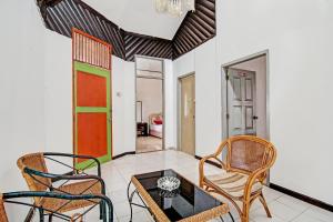 北干巴鲁OYO 92331 Rindu Sempadan Cottage的客厅配有两把椅子和一张桌子