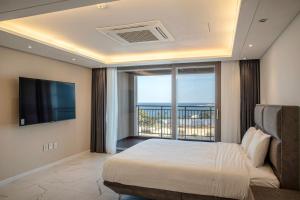 济州市Villa de Aewol的一间卧室设有一张大床和一个大窗户