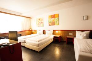 科隆Trip Inn Hotel Ariane的酒店客房设有两张床和一张桌子。