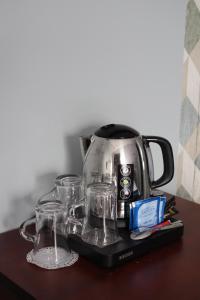 凯恩克洛库斯酒店的桌上的盘子上的一个咖啡壶和玻璃杯