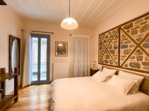 纳夫普利翁Μπαλκόνι的卧室配有白色的床和大墙