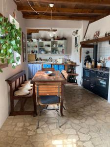 菲纳莱利古雷Casa Olivia Lacremà的厨房配有木桌和椅子