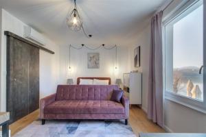 KismarosDuna P'Art Panzió的客厅配有紫色沙发和窗户