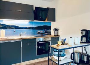 蒂蒂湖-新城Ferienwohnung Niki的厨房配有蓝色橱柜和水景台面