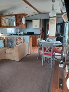 SeasalterVista Caravan Hire的客厅以及带沙发和桌子的厨房。