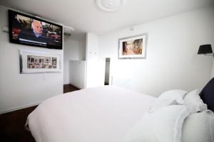 莫尔科泰"Fall in love only" Morcote lake的卧室配有白色的床和平面电视。