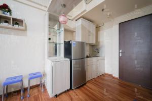 雅加达RedLiving Apartemen Sunter Park View - Emma Rooms的厨房配有冰箱和2张蓝色凳子