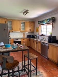 Vila ChãFerienhaus Casa do mar mit seitlichem Meerblick的厨房配有木制橱柜和桌椅