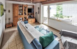 Stiege1 Bedroom Cozy Home In Stadt Oberharz Am Broc的客厅配有蓝色的沙发和玻璃桌