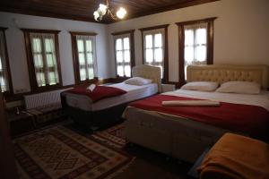 番红花城mehmet efendi的一间带两张床的卧室,位于带窗户的房间内