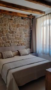 圣特雷莎加卢拉Il Busciolotto的砖墙客房内的一张大床