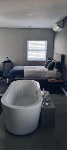 约翰内斯堡Cottage in Sandton的卧室配有白色浴缸,卧室配有床
