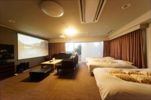 热海熱海の隠れ里的酒店客房设有三张床和大屏幕