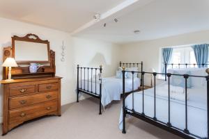 斯托昂泽沃尔德Honey Cottage的卧室内的两张床,配有镜子和梳妆台