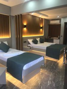代尼兹利Pamukkale Apollon Garden的酒店客房,配有两张带绿床单的床