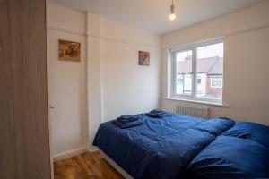利物浦Cheerful and modern 3 BDR for 7的一间卧室设有蓝色的床和窗户。