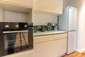利物浦Cheerful and modern 3 BDR for 7的厨房配有炉灶和冰箱。