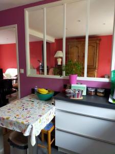 比亚里茨House with garden in Biarritz - quiet area的厨房设有红色的墙壁和一张桌子及柜台