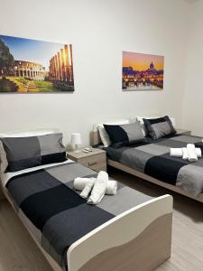 罗马Palmira's Rome Sweet Home的一间卧室设有两张床,墙上挂着一幅画