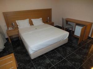努瓦迪布Hotel El Medina的卧室配有一张白色大床和一张书桌