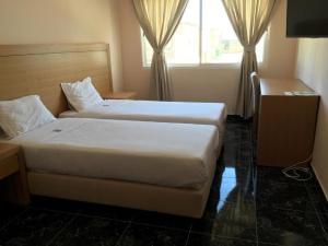 努瓦迪布Hotel El Medina的酒店客房设有两张床和窗户。