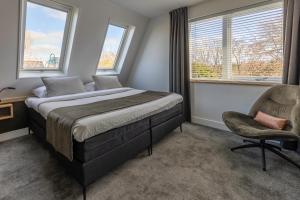 德科赫特克塞尔果岭酒店的一间卧室配有一张床、一把椅子和窗户。