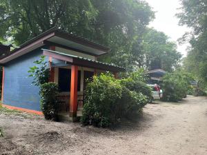泰孟Garden Bungalow Resort的一座蓝色的小房子,旁边停有一辆汽车