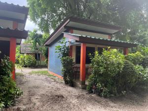 泰孟Garden Bungalow Resort的蓝色和红色外墙的小房子