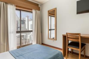 维塞乌蒙霍德文托酒店的一间卧室配有一张床、一张书桌和一个窗户。