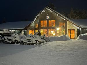 Boulder JunctionBoulder Bear Motor Lodge的雪覆盖的房屋,晚上有灯