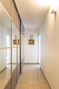 斯特拉斯堡莫扎特公寓的走廊设有白色墙壁和瓷砖地板