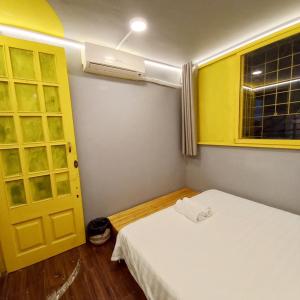 河内Hanowood Homestay的一间设有床、窗户和黄色门的房间
