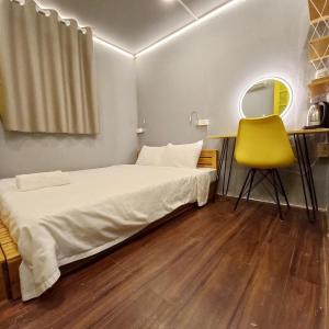河内Hanowood Homestay的一间卧室配有一张床和一张黄色椅子