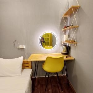河内Hanowood Homestay的小房间设有书桌和黄色椅子