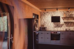 DalhemÔ NaNo Glamping的带冰箱的厨房和墙上的电视