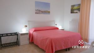 维耶斯泰B&B Armonia Vieste的一间卧室配有红色的床和2个床头柜