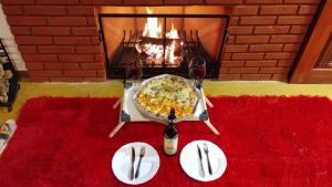 贡萨尔维斯Chales Sabor Dos Ventos的一张桌子,上面有比萨饼和壁炉