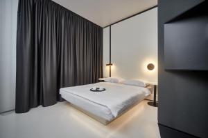 敖德萨Sunday Rooms的卧室配有白色的床和黑色窗帘