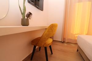 希马拉Fegi Rooms的一张黄色椅子坐在一张桌子下面