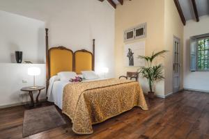 德尼亚查马雷尔艺术精品酒店的一间卧室配有一张带黄色床罩的大床