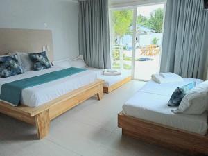 托卢Oasis Tolú Hotel Boutique的卧室设有两张床,享有庭院的景色