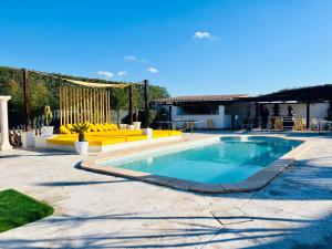 马略卡岛帕尔马Villa Copacabana Súper Lujo的一个带黄色家具的庭院内的游泳池