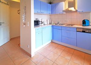 巴贝Ferienwohnung Seestern (Ref. 128659u1)的厨房配有蓝色橱柜,铺有瓷砖地板。