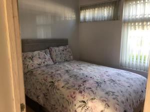 彭布罗克郡Happy Chalet的一间卧室配有一张带花卉床罩的床