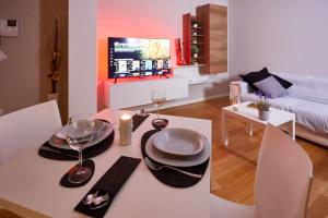 阿维亚诺Center Aviano Comfort Suite FREE PARKING WIFI的客厅配有带盘子和酒杯的桌子