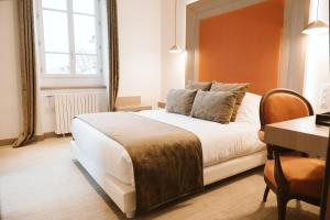 Saint-Sulpice多迈纳恩法戈酒店的酒店客房配有一张床铺、一张桌子和一张书桌。