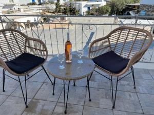 安迪帕罗斯岛Hotel Chrisoula的一张桌子、两把椅子和一瓶葡萄酒