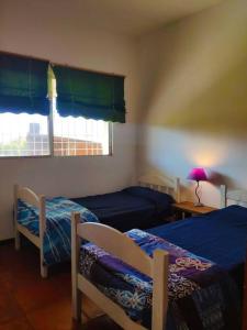 新帕尔米拉Casa rural的一间卧室设有两张床和窗户。