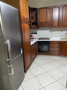 蒙德拉戈内Casa San Francesco的厨房配有木制橱柜和不锈钢冰箱。