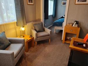 布里克瑟姆Brookside Guest House & Mini Spa的客厅配有沙发和椅子